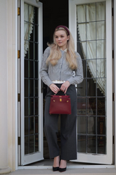 a lady in a grey sweater, a white shirt and a pair of black pants